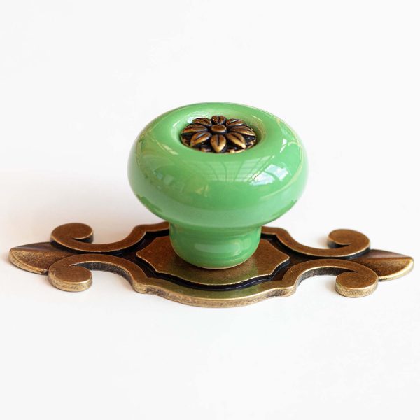 Buton de mobilă din ceramică verde cu plăcuță decorativă, ideal pentru sertare, dulapuri și noptiere în stil vintage.